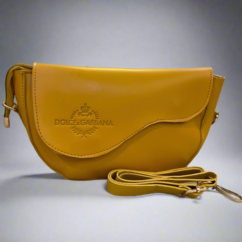 Yellow Dolce & Gabbana handbag on a surface with a blurred background