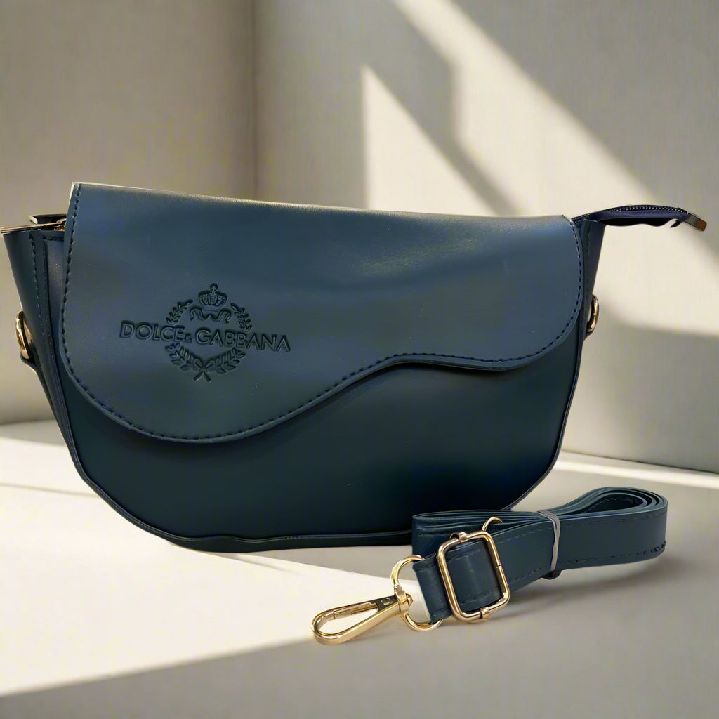 Blue handbag with gold accents on a surface, with a blurred background