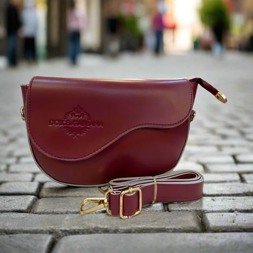 Red handbag with gold accents on a marble surface in an indoor setting